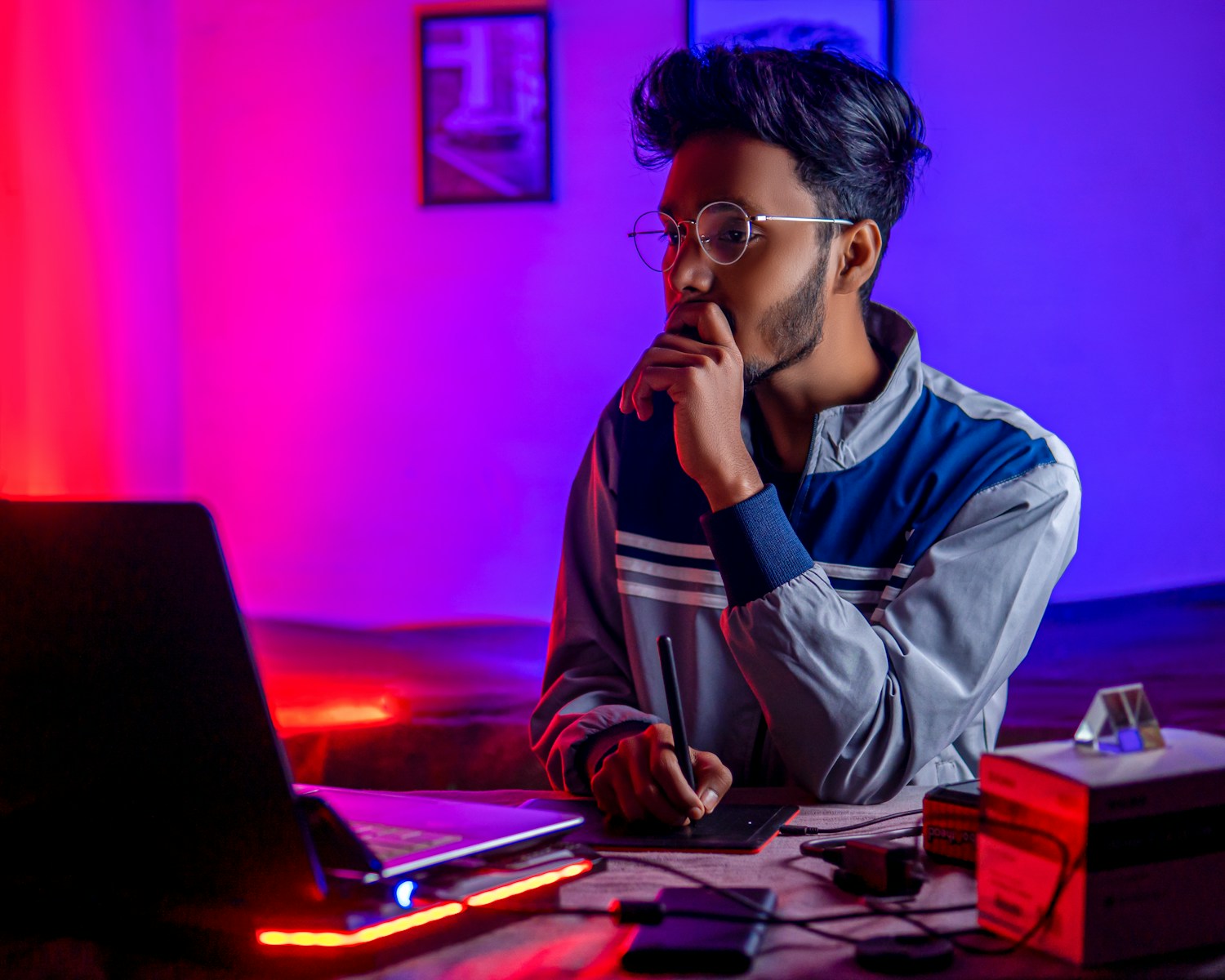 a person sitting at a desk with a laptop and a computer